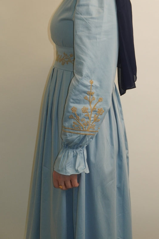 Blue cotton sateen maxi dress side view, showing structured bodice and pleated skirt